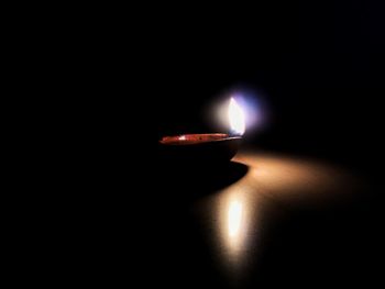 Close-up of lit candle in dark room