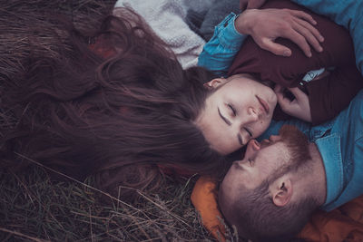 High angle view of couple lying on grass outdoors