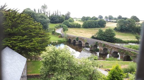 Arch bridge over river against sky