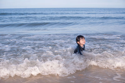 Cheerful girl swimming in sea