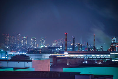 Illuminated cityscape against sky at night