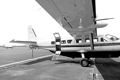 Airplane on airport runway against sky