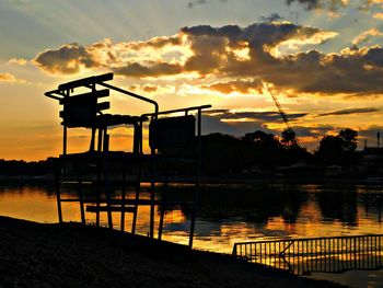 Silhouette built structure against dramatic sky during sunset