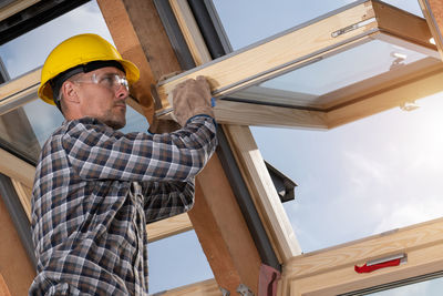 Low angle view of young man standing against building