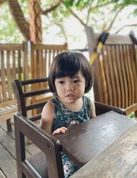 Portrait of cute girl sitting on seat