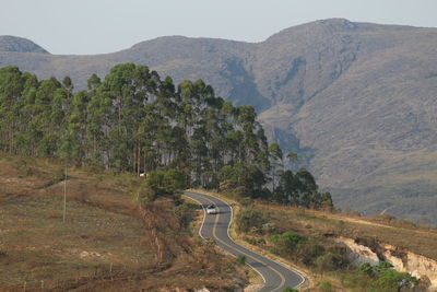 Scenic view of road by mountains against sky