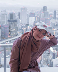 Portrait of young woman looking at cityscape