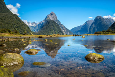 Scenic view of lake and mountains against blue sky