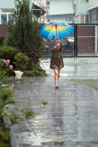 Rear view of woman with umbrella standing in water