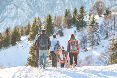 People skiing on snow covered landscape