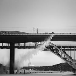 Bridge over river against sky in city