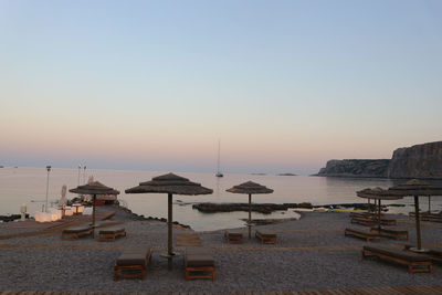 Scenic view of beach against clear sky during sunset