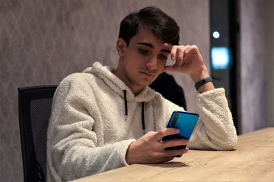 Side view of young man using mobile phone