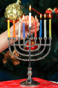 Menorah with candles for hanukkah on the background of the new year tree