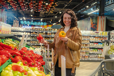 Portrait of young woman standing in supermarket