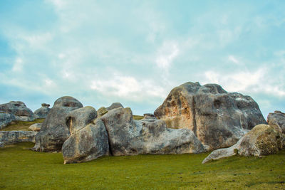 Rocks on field against sky