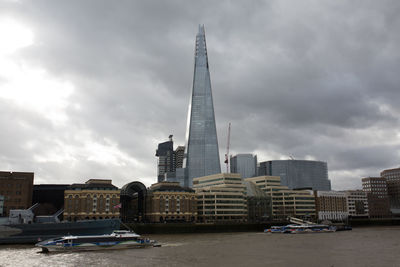 View of buildings in city against cloudy sky