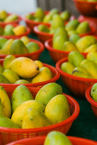 Fresh mangoes in red baskets at the stall.