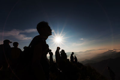 Silhouette people against sky during sunny day