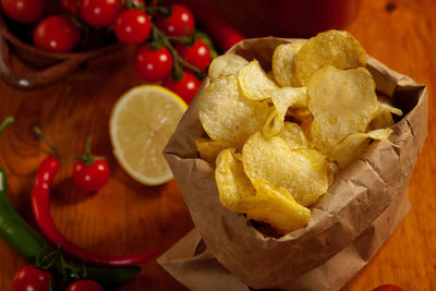 Close-up of potato chips with cherry tomatoes on table