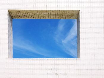 Sky seen through window of tiled wall