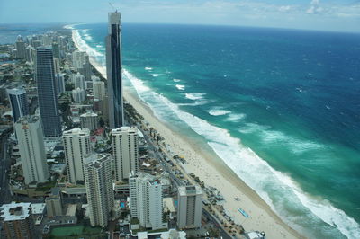 High angle view of city by sea against sky