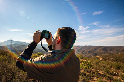 Rear view of man photographing