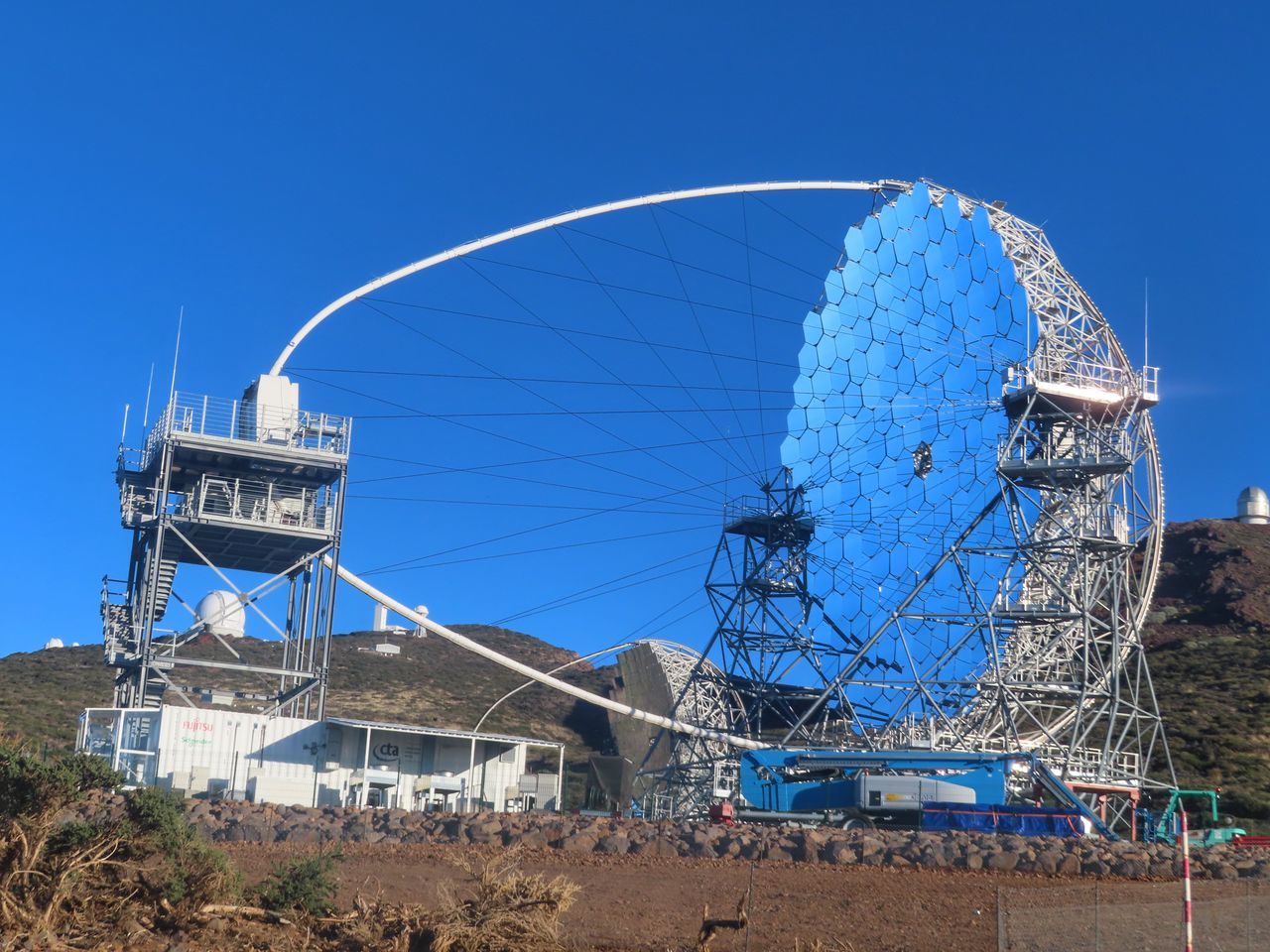 sky, radio telescope, blue, architecture, built structure, nature, ferris wheel, clear sky, amusement park ride, amusement park, travel destinations, day, arts culture and entertainment, no people, outdoors, landmark, technology, sunny, travel, land, tourism, stadium, building exterior, antenna, satellite dish