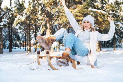 Side view of woman with dog on snow covered field