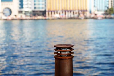 Rusty aged lamppost by creek canal water