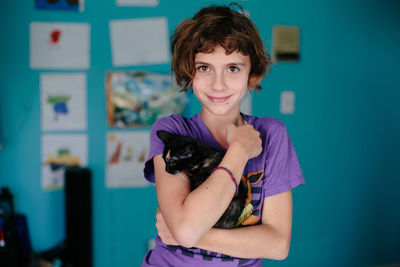 Girl looks into camera happy while she holds a kitten