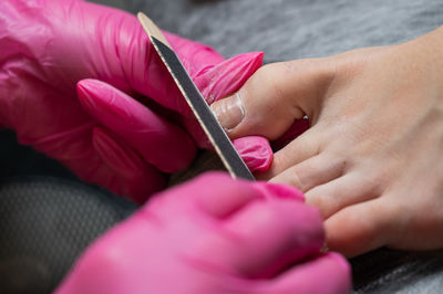 Cropped hands of person repairing nail
