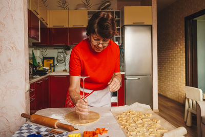 Young man preparing food in kitchen at home