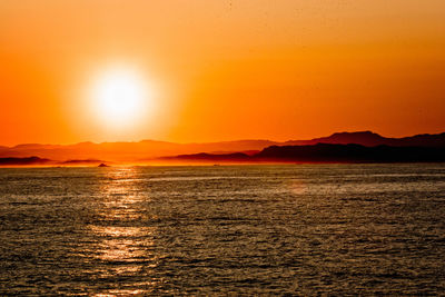 Scenic view of sea against orange sky