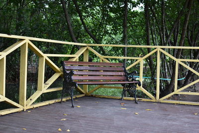 Chairs on railing against trees