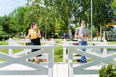 Young couple standing on table against trees