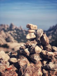 Stack of stones on rock against sky