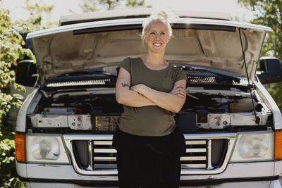 Woman standing in front of car