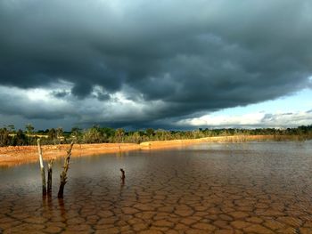 Scenic view of landscape against storm clouds