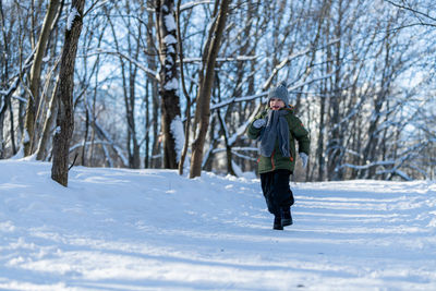 Full length of woman skiing on snow covered field