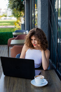 Young woman using laptop at table