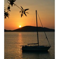 Sailboat in sea at sunset