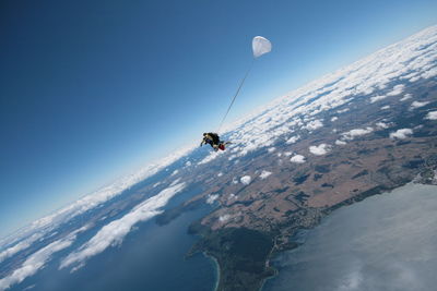 Man paragliding against clear blue sky