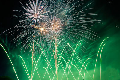 Low angle view of green firework display at night