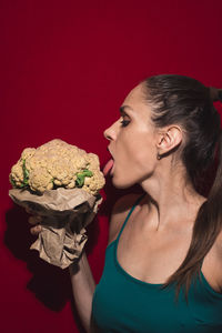 Side view of woman licking vegetable