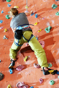 Rear view full length of woman climbing wall