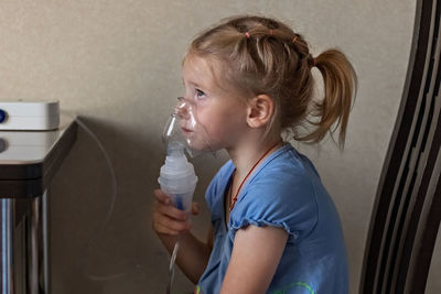 Portrait of boy drinking water at home