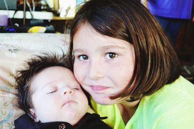 Close-up portrait of girl with baby brother at home