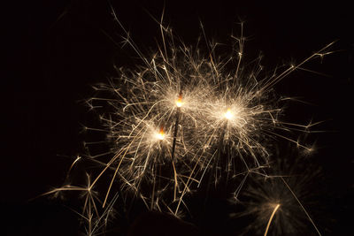 Burning sparklers in front of a black background