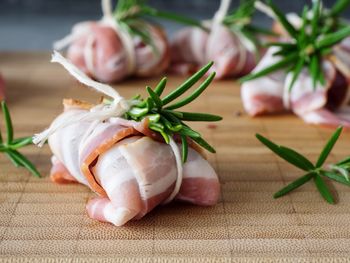 Meat tied with rosemary on cutting board